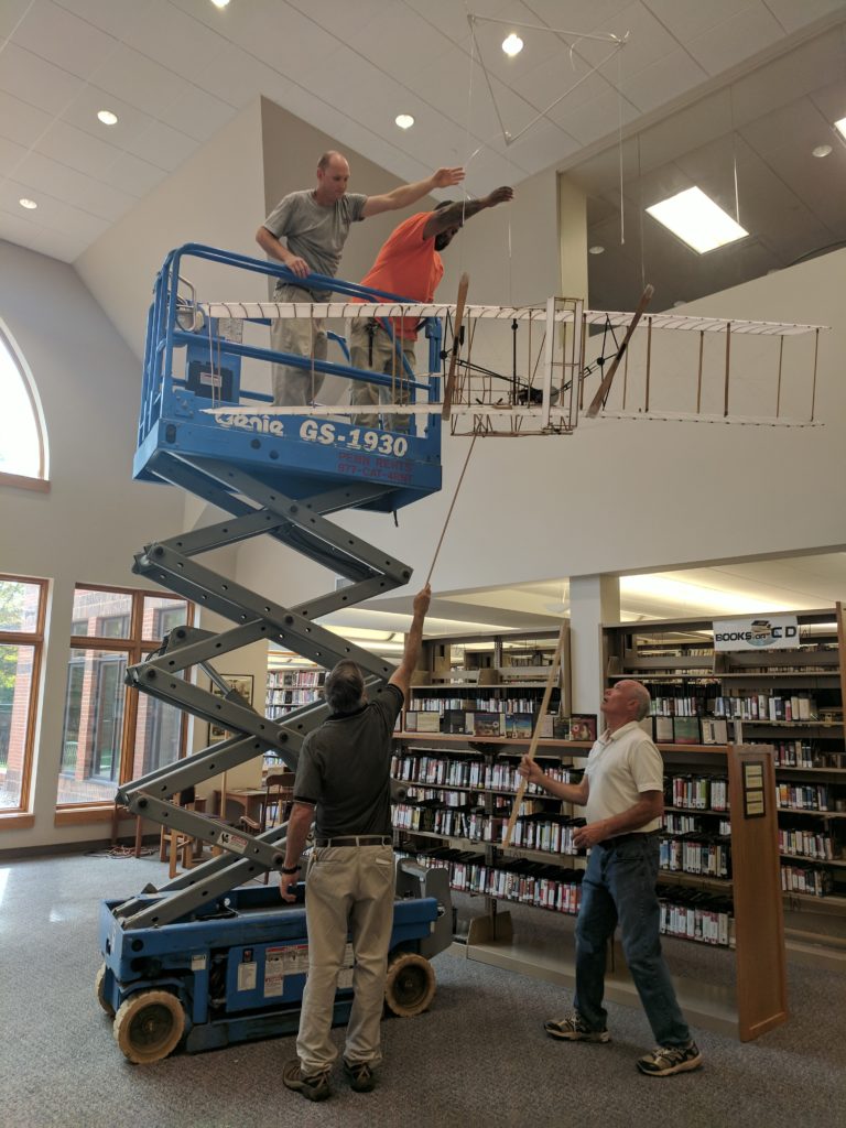 Wright plane being hung up in the library